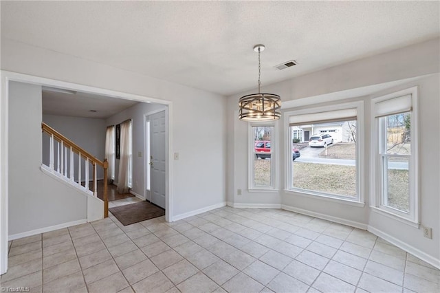 unfurnished dining area featuring light tile patterned floors, visible vents, baseboards, stairs, and an inviting chandelier