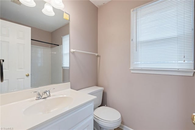 full bath with a wealth of natural light, walk in shower, vanity, and toilet