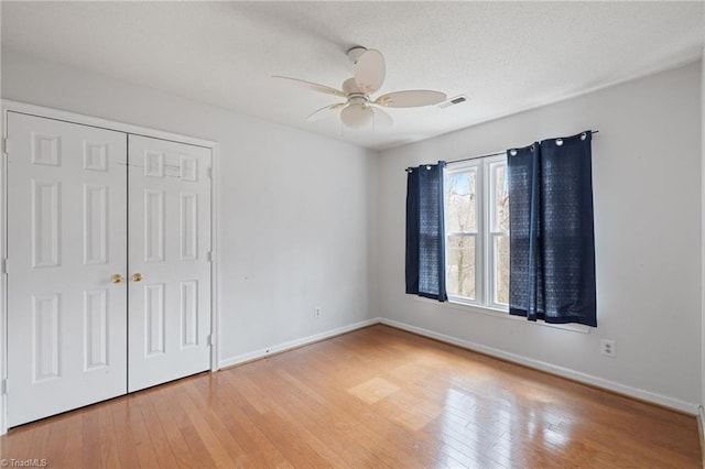 unfurnished bedroom with light wood-style flooring, a closet, visible vents, and baseboards