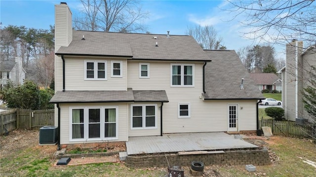 rear view of property featuring a patio area, a fenced backyard, a chimney, and central AC unit