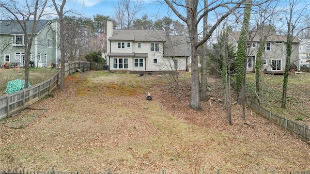 back of property with a chimney, fence, and a residential view