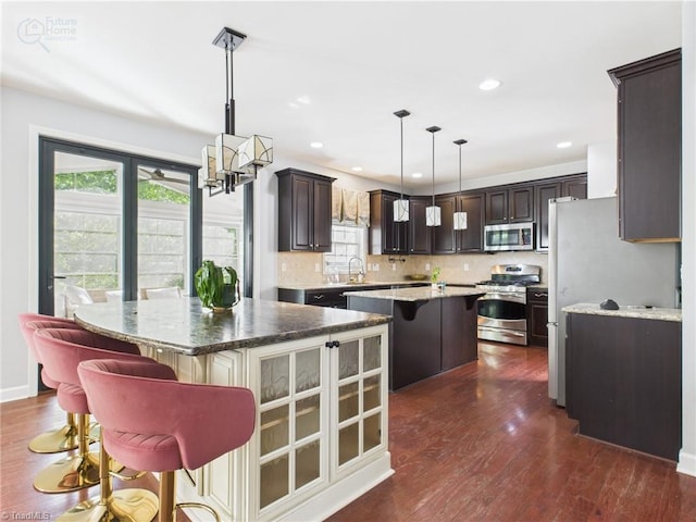 1728 Callandale Ave, Cary, NC 27518 - kitchen featuring stainless steel appliances, a center island, a sink, dark brown cabinets, and dark wood-style floors