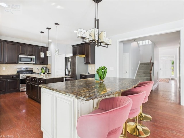 1728 Callandale Ave, Cary, NC 27518 - kitchen with stainless steel appliances, a kitchen island, dark wood finished floors, and dark brown cabinetry