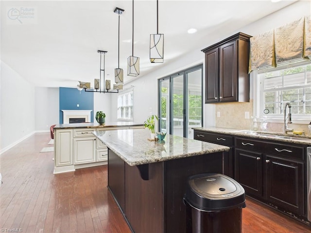 1728 Callandale Ave, Cary, NC 27518 - kitchen with a sink, a center island, light stone counters, open floor plan, and dark wood-style flooring