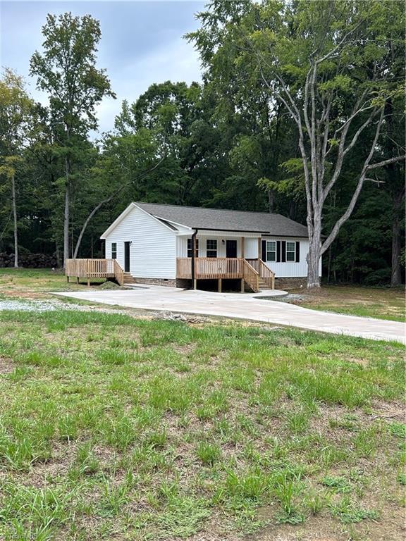 view of front of house featuring a front lawn and a deck