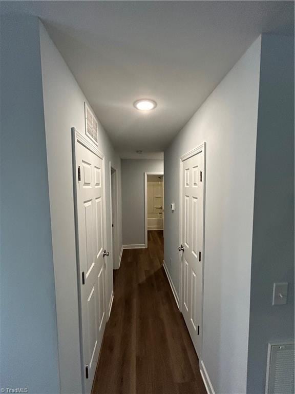 corridor with dark hardwood / wood-style flooring