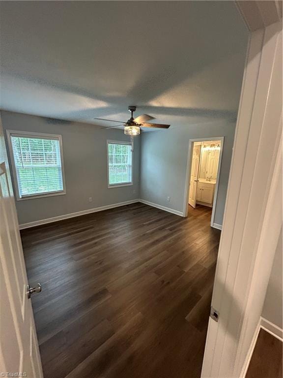 unfurnished bedroom with ceiling fan and dark hardwood / wood-style floors