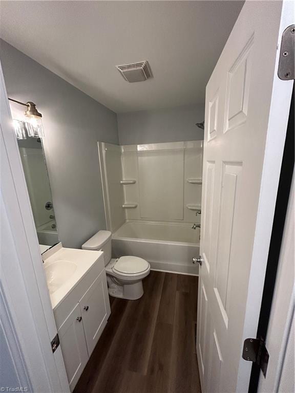 full bathroom with shower / bathtub combination, wood-type flooring, toilet, and vanity