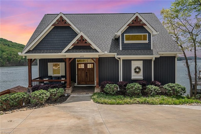 602 Shoreline Rd, New London, NC 28127 - view of front facade featuring board and batten siding, roof with shingles, a water view, and a porch