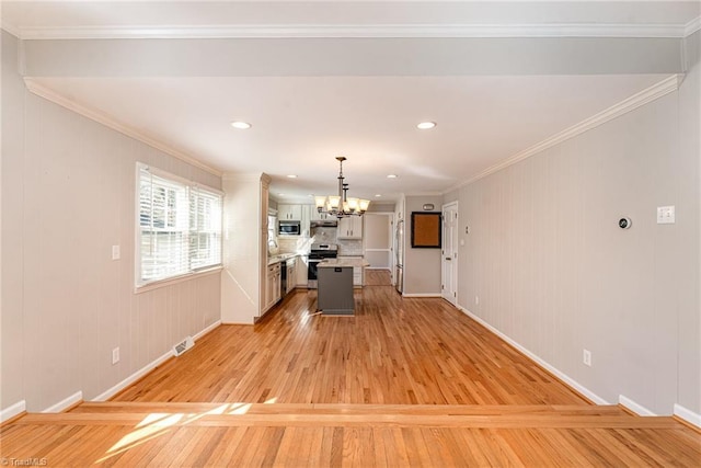 kitchen featuring stainless steel appliances, a chandelier, ornamental molding, and light wood finished floors