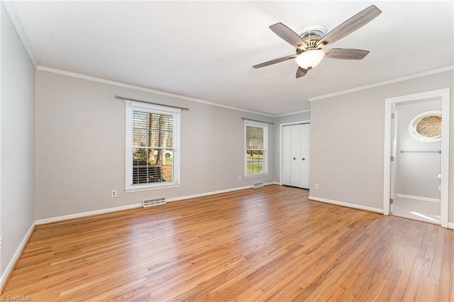 empty room featuring baseboards, a wealth of natural light, and light wood-style floors