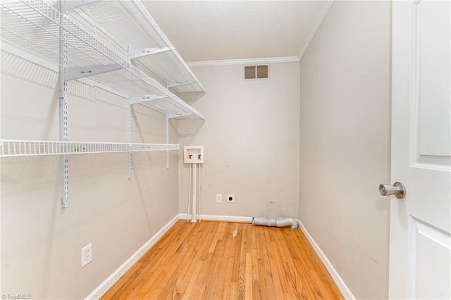 clothes washing area featuring hookup for a washing machine, laundry area, wood finished floors, visible vents, and ornamental molding