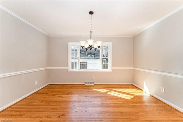 unfurnished dining area featuring crown molding, visible vents, a notable chandelier, and wood finished floors