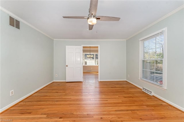 unfurnished room featuring baseboards, ornamental molding, visible vents, and light wood-style floors