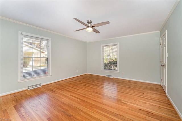 unfurnished room featuring ornamental molding, light wood-style flooring, and visible vents