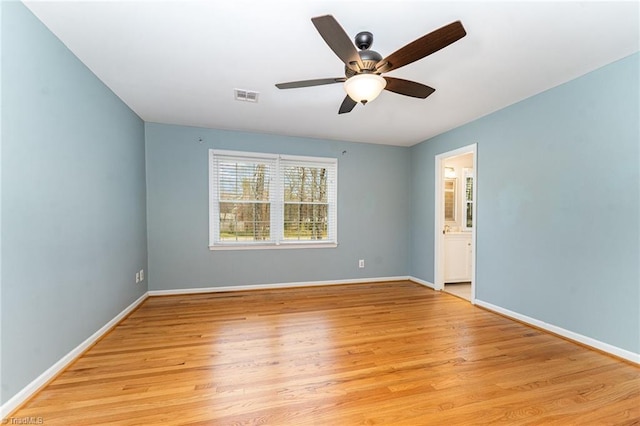 unfurnished room featuring baseboards, ceiling fan, visible vents, and light wood-style floors