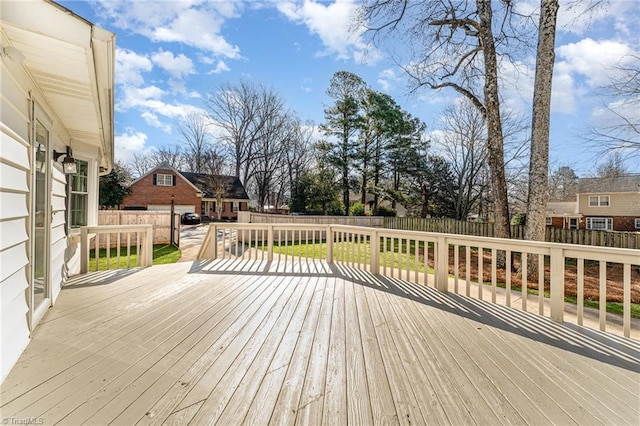 wooden terrace with a fenced backyard