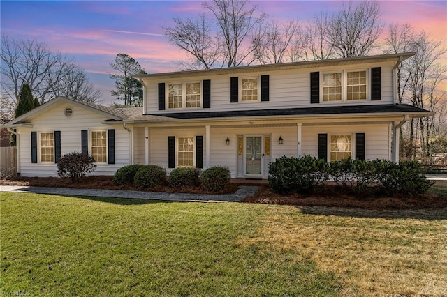 view of front facade featuring covered porch and a lawn