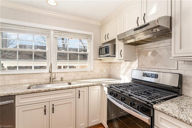 kitchen with crown molding, stainless steel appliances, white cabinets, a sink, and under cabinet range hood