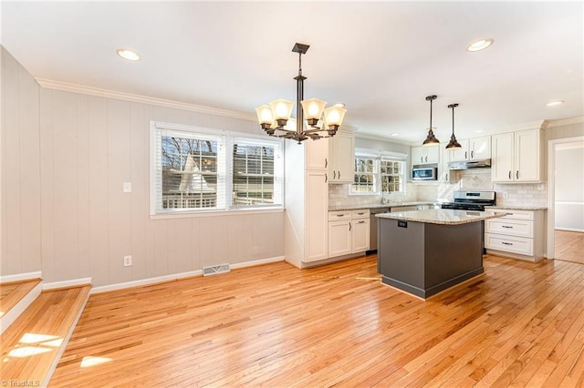 kitchen featuring stainless steel appliances, visible vents, light wood finished floors, and white cabinetry