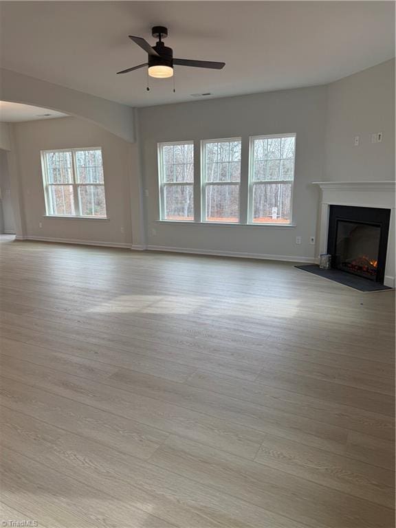 unfurnished living room featuring ceiling fan and light hardwood / wood-style floors