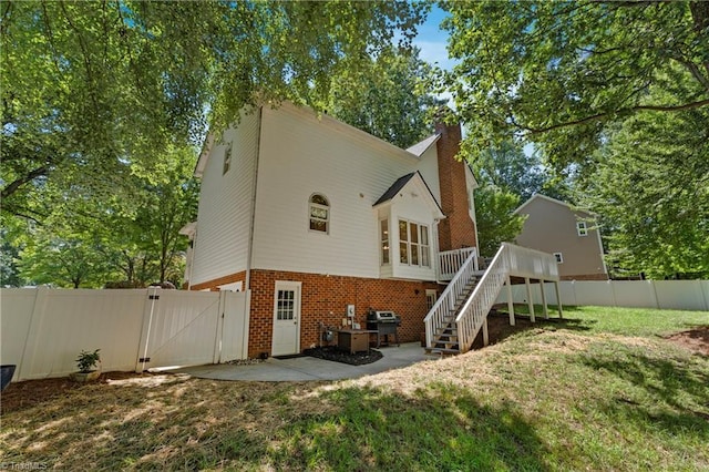 396 Bent Creek Trl, Kernersville, NC 27284 - rear view of property featuring a gate, brick siding, stairway, a fenced backyard, and a chimney