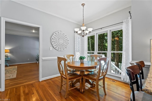 396 Bent Creek Trl, Kernersville, NC 27284 - dining area with a chandelier, crown molding, and wood finished floors