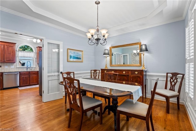 396 Bent Creek Trl, Kernersville, NC 27284 - dining space featuring a chandelier, light wood-style floors, a raised ceiling, wainscoting, and crown molding