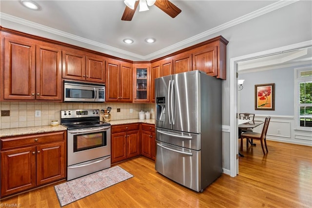 396 Bent Creek Trl, Kernersville, NC 27284 - kitchen with stainless steel appliances, light wood-style flooring, a ceiling fan, ornamental molding, and glass insert cabinets