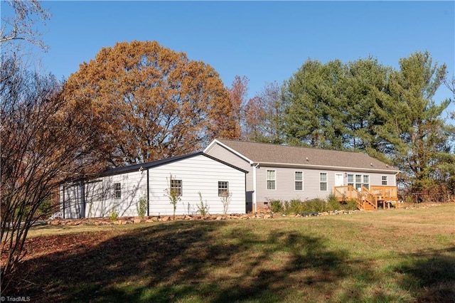 back of house featuring a wooden deck and a yard