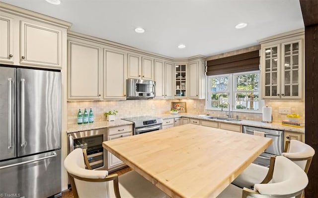 kitchen featuring stainless steel appliances, cream cabinets, and sink