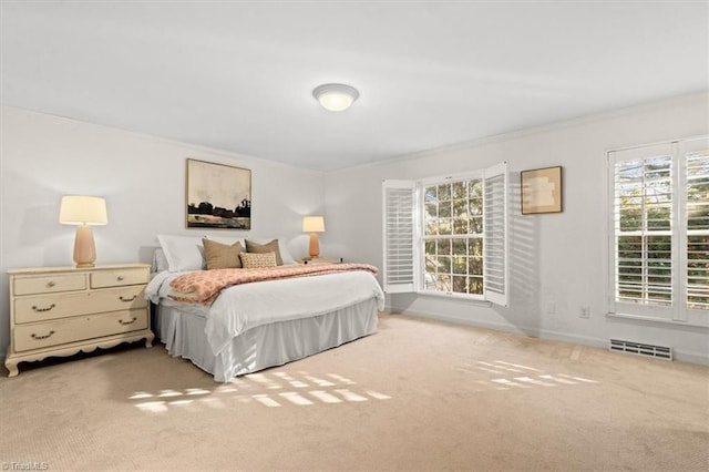 bedroom featuring multiple windows, ornamental molding, and carpet