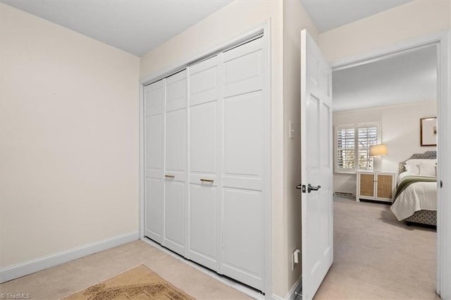 bedroom with light carpet and a closet