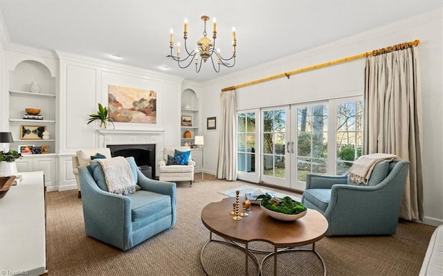 sitting room with french doors, ornamental molding, a notable chandelier, and built in shelves