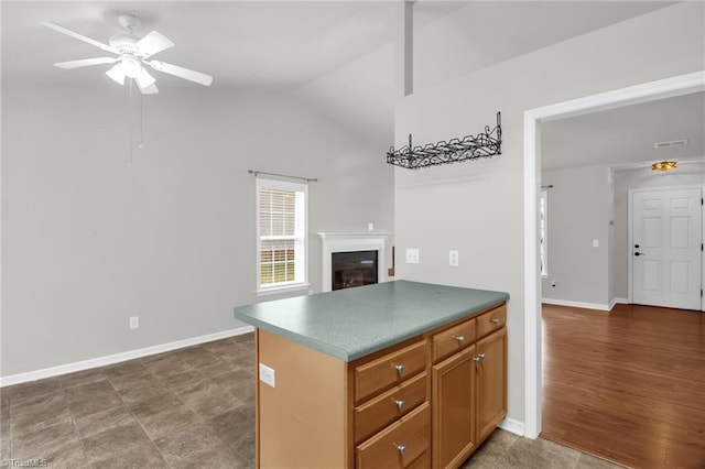 3931 Hickswood Forest Dr, High Point, NC 27265 - kitchen with ceiling fan, a glass covered fireplace, lofted ceiling, baseboards, and dark countertops
