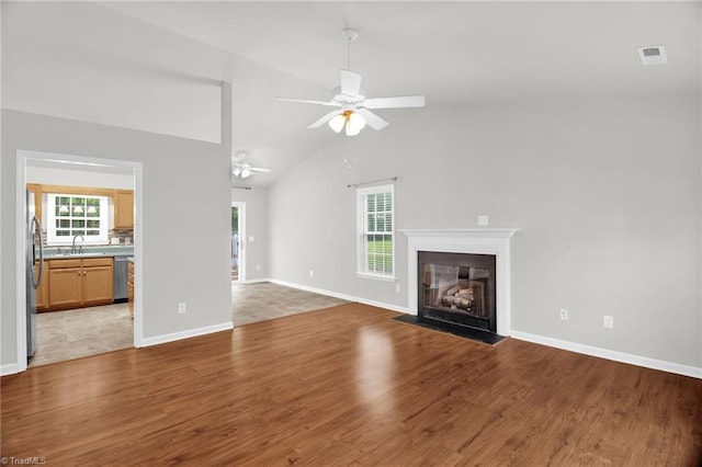 3931 Hickswood Forest Dr, High Point, NC 27265 - unfurnished living room with light wood-style flooring, ceiling fan, a fireplace with flush hearth, a sink, and baseboards
