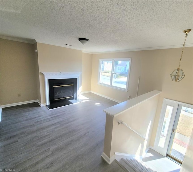 living area featuring a textured ceiling, dark wood-type flooring, a fireplace, baseboards, and ornamental molding