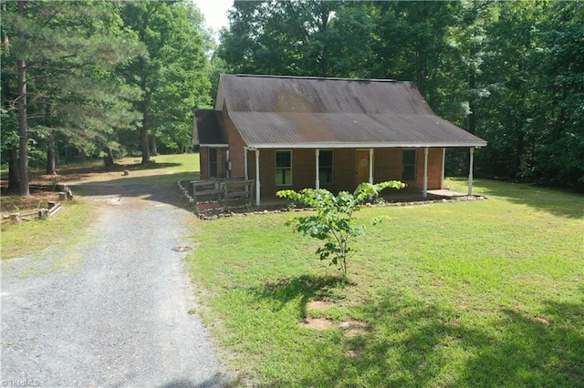 5864 Whites Chapel Rd, Staley, NC 27355 - view of front of home featuring gravel driveway, a porch, a front lawn, and a wooded view