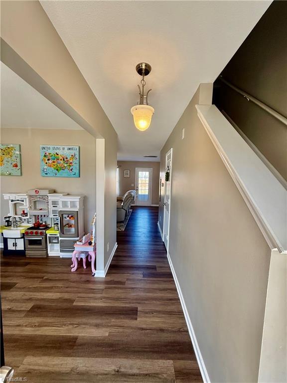 hall with baseboards and wood finished floors