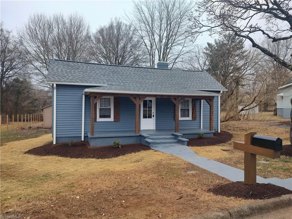 bungalow with a front yard and covered porch