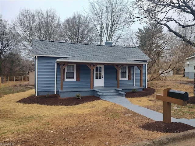 bungalow with a front yard and covered porch