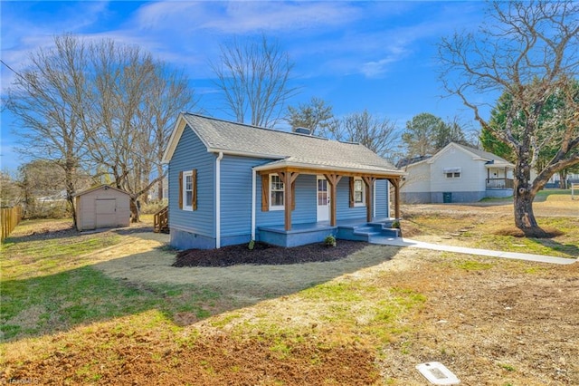 bungalow-style house with a porch, a storage unit, and a front yard