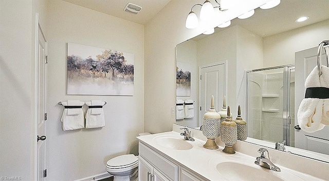 bathroom with vanity, toilet, and a shower with shower door