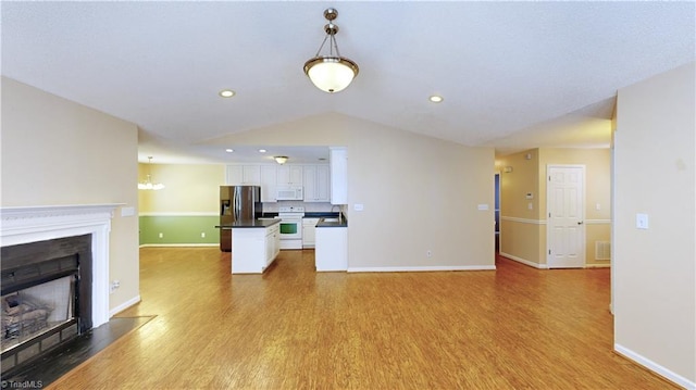 unfurnished living room with light hardwood / wood-style floors and vaulted ceiling