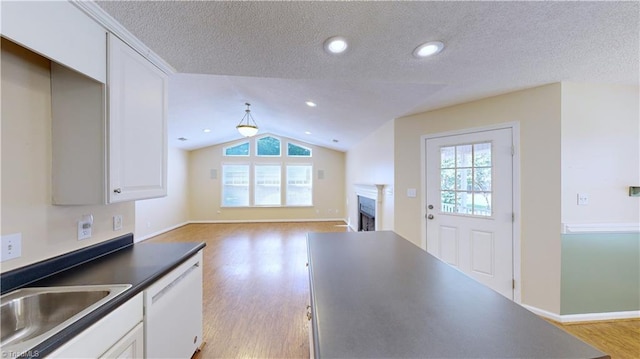 kitchen featuring plenty of natural light, dishwasher, light wood-type flooring, and vaulted ceiling