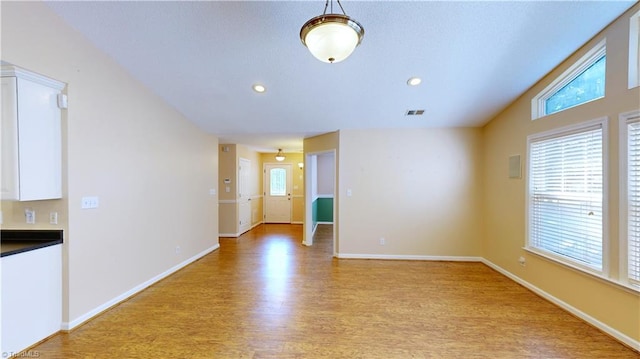 spare room with light hardwood / wood-style flooring and vaulted ceiling