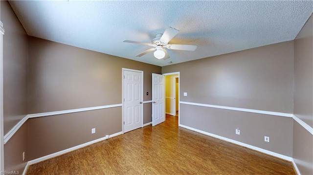 empty room with ceiling fan, light hardwood / wood-style flooring, and a textured ceiling