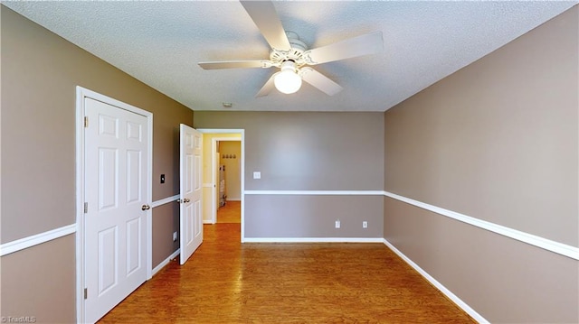 spare room featuring ceiling fan, a textured ceiling, and hardwood / wood-style flooring