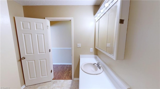 bathroom featuring tile patterned floors, vanity, and a textured ceiling