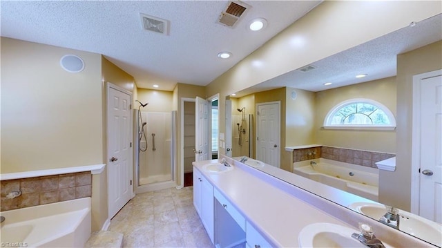 bathroom featuring vanity, a textured ceiling, independent shower and bath, and tile patterned flooring